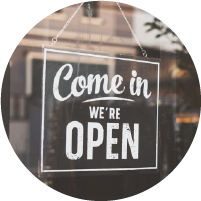 small black sign on a business window reading